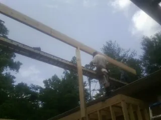 Carpenter setting a ridge beam over a new addition frame — Ice Dam Removal by Roofing Brothers in Summer Shade