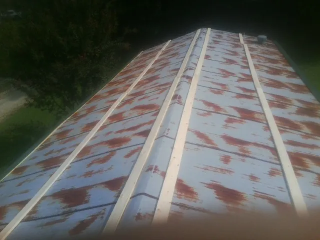 Rusted metal roof panels with new wood purlins before replacement — Storm Damage Roof Repair in Summer Shade by Roofing Brothers