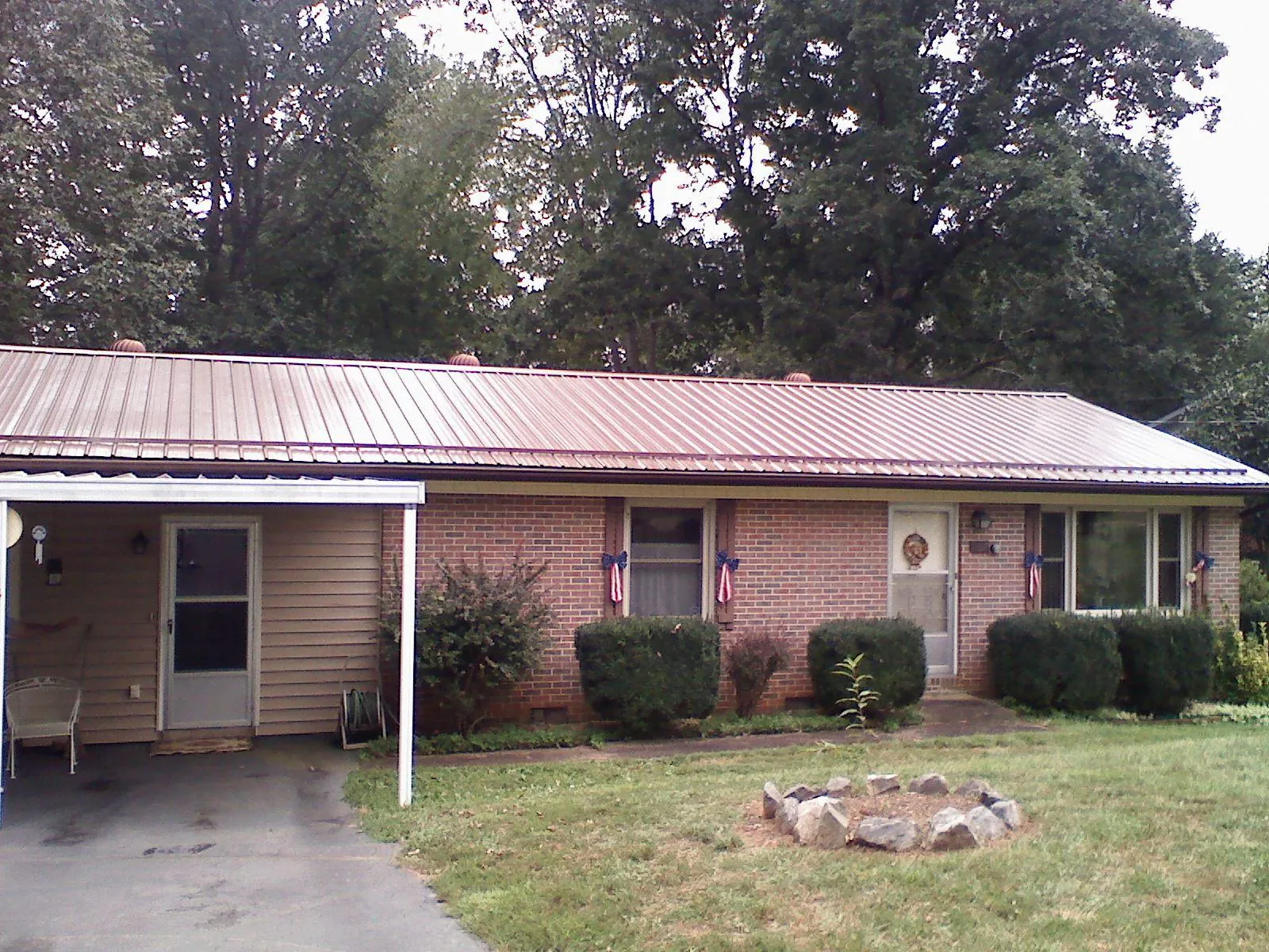 Bronze metal roof and carport on a brick ranch home — Roof Repair work by our crew in Summer Shade